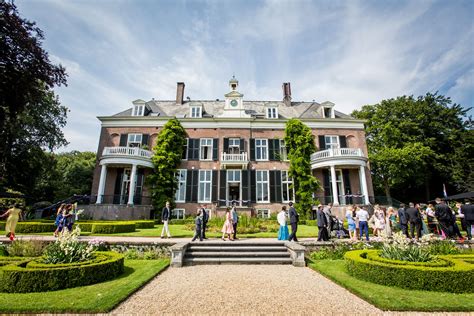 Historic estate building with formal garden and people walking, showcasing landscape architecture and integration of nature and heritage