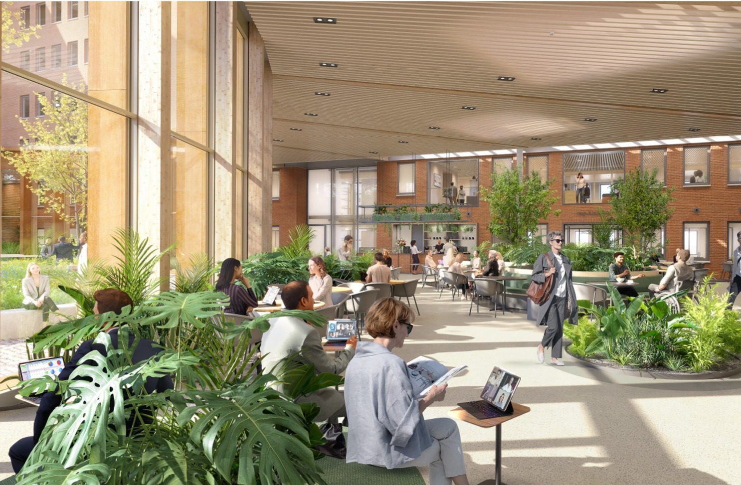 A spacious, light-filled atrium in a sustainable office environment, featuring lush greenery, including trees and ferns. Employees and visitors engage in casual conversations, work at tables, and walk through the space. A large staircase leads to an upper level with offices, visible through glass partitions in a repurposed brick structure. Sunlight filters through the ceiling’s wooden slats, and a green wall enhances the biophilic atmosphere, creating a dynamic yet calming workplace.
