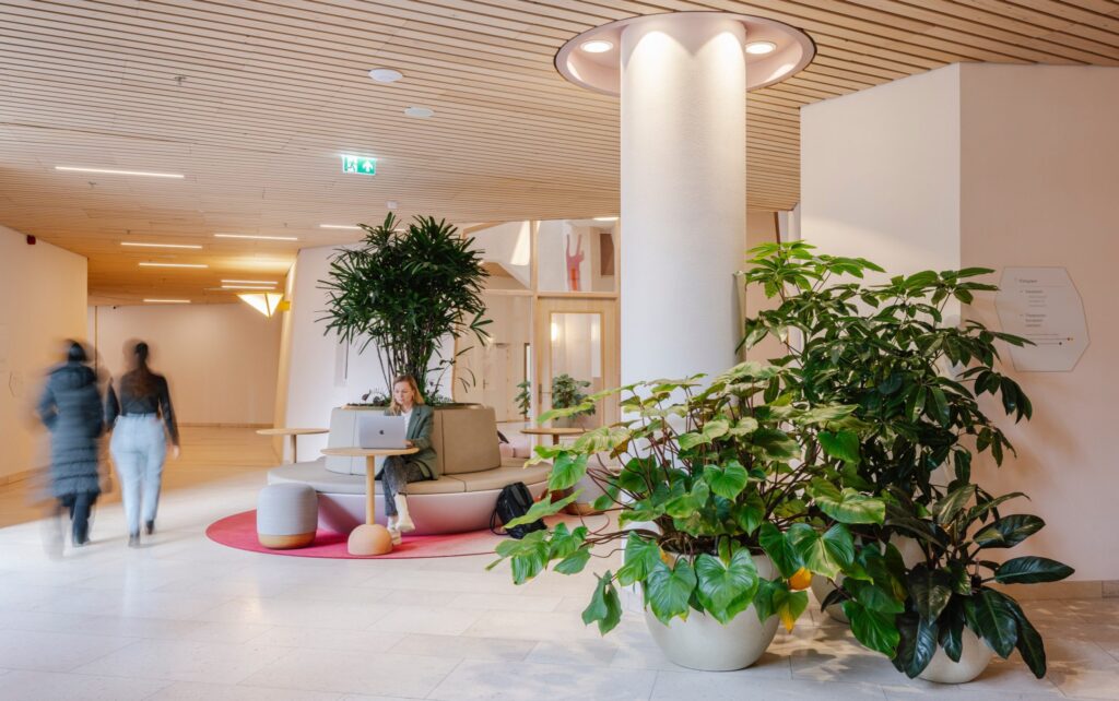 Zitplek met interieurbeplanting in de binnenruimte van het Zandkasteel Amsterdam, waar werken en doorstroming samenkomen.