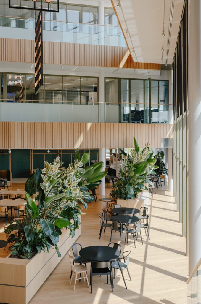 Binnenruimte bij Galapagos Leiden met grote plantenbakken, zitplekken en daglicht in een groen kantooratrium.