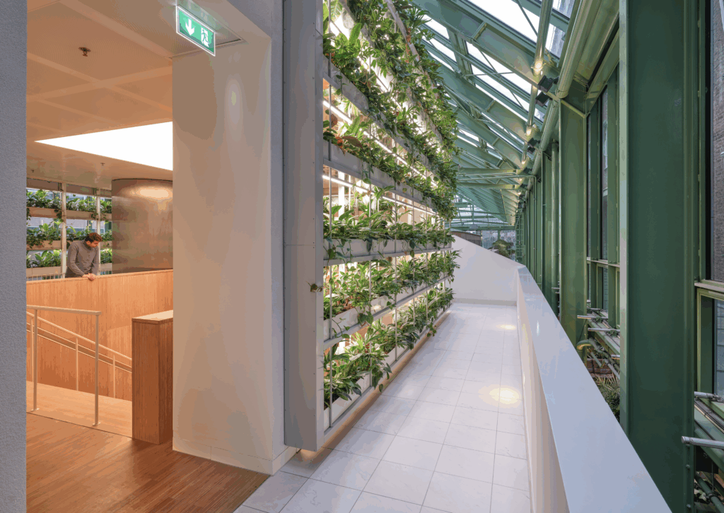 Groene gevelwand met geïntegreerde verlichting en planten in Rijkskantoor B73 Den Haag, ontworpen door MOSS en Fokkema & Partners, duurzaam kantoorontwerp met biophilic elementen.