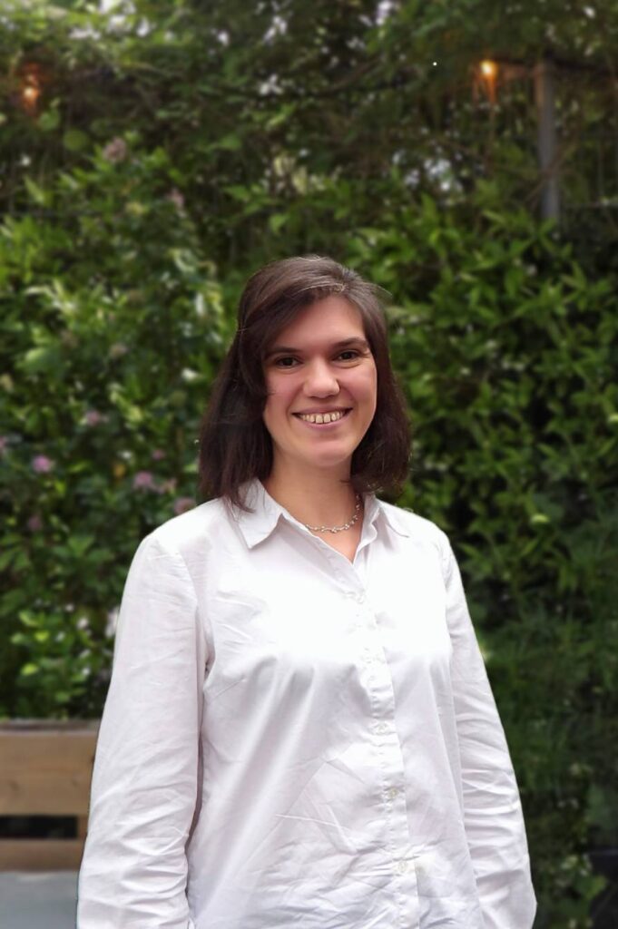 Smiling portrait of Eirini Trachana from MOSS in a natural garden environment reflecting the company's connection to nature and sustainable design.