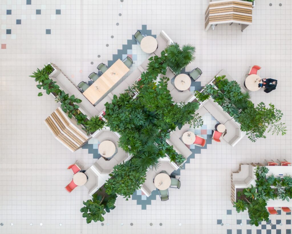 Biophilic indoor landscape at Dr. Sarphatihuis Amsterdam featuring modular seating, abundant greenery, and flexible communal spaces for elderly residents.