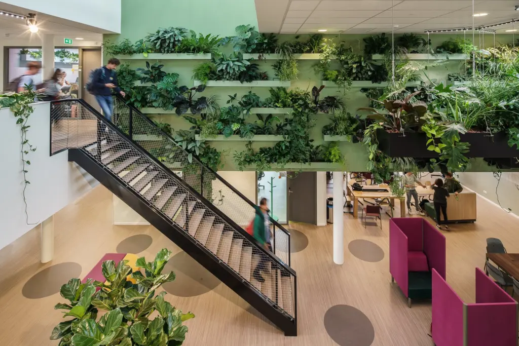 Interior staircase and living green wall at Aeres Hogeschool Almere with integrated tropical planting and collaborative educational spaces.