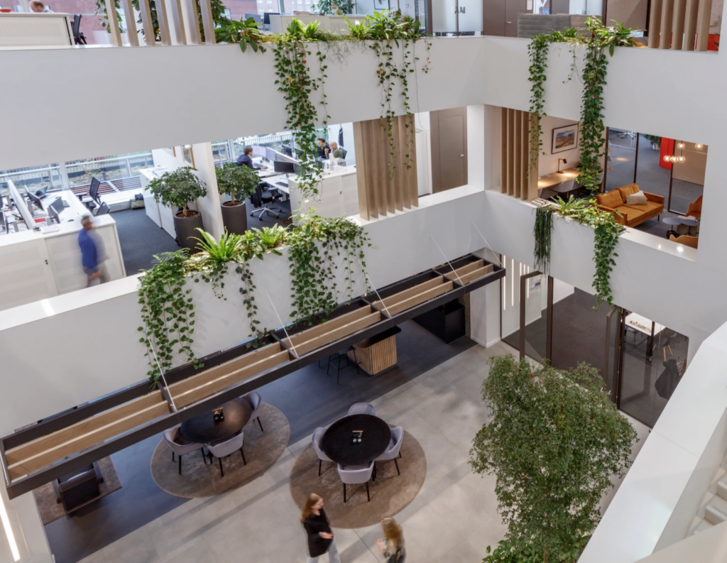 Multi-story office atrium with cascading plants and biophilic workspace design at AM-Office Utrecht by MOSS