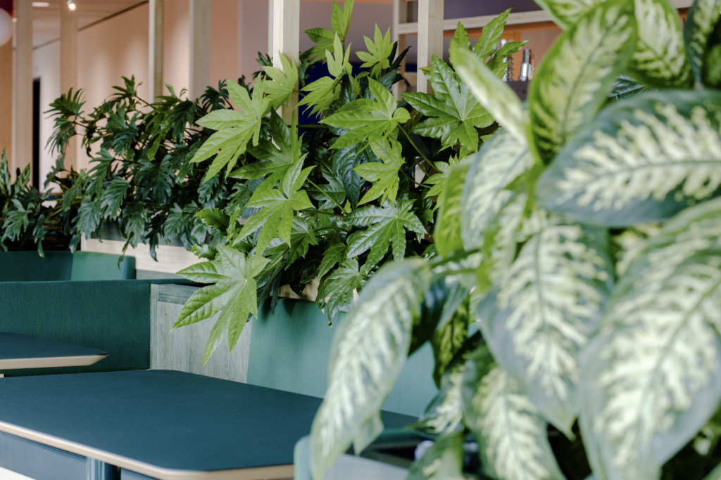 Multi-level atrium with indoor planting and green balconies at Booking.com Campus Amsterdam biophilic office design