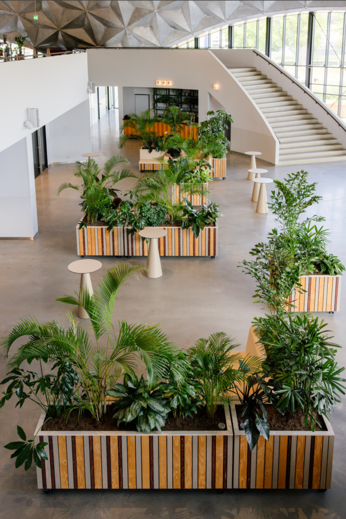 Biophilic interior by MOSS at Circa Amsterdam featuring modular wooden planters, tropical planting, seating areas, and the iconic geodesic dome in the Netherlands' first circular event venue.