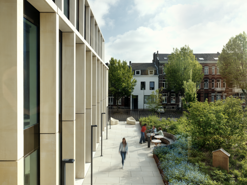 Green courtyard edge at DSM-Firmenich Maastricht with native planting, pedestrian walkway, and sustainable office landscape design