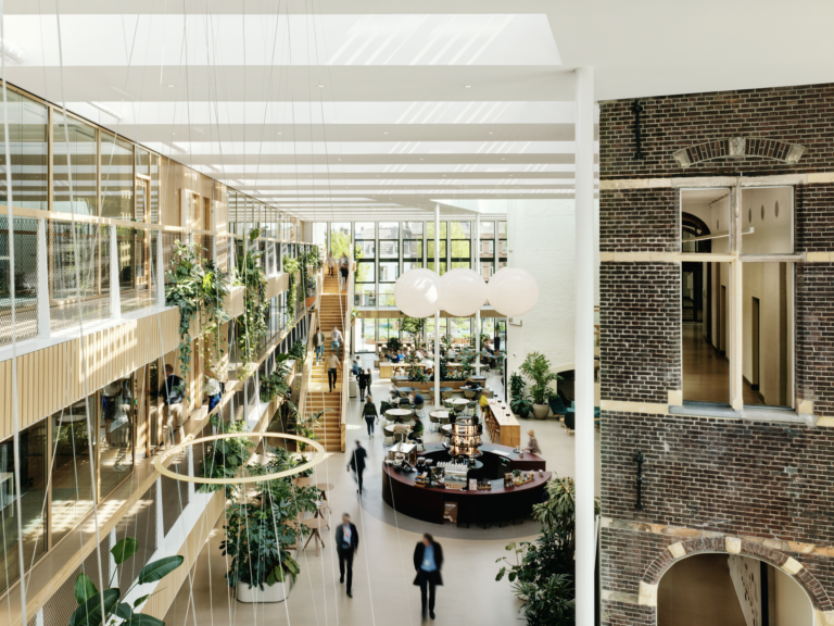Biophilic atrium at DSM-Firmenich Maastricht combining historic brick architecture with modern sustainable office design and integrated indoor greenery