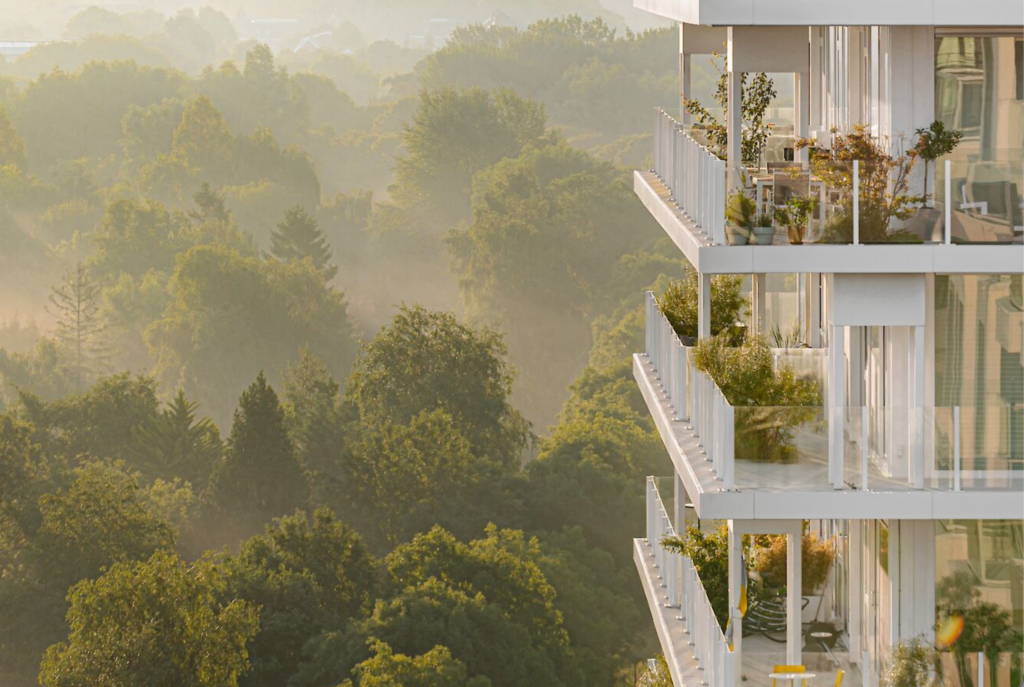 Green terrace detail at De Voortuinen Amsterdam showing planted balconies with trees and shrubs overlooking urban nature