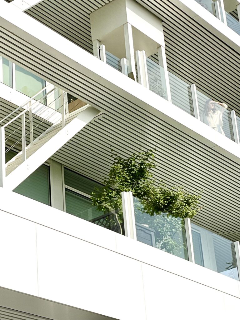 Modern residential façade at Voortuinen Amsterdam featuring planted balconies and nature-inclusive architecture designed to support urban biodiversity.