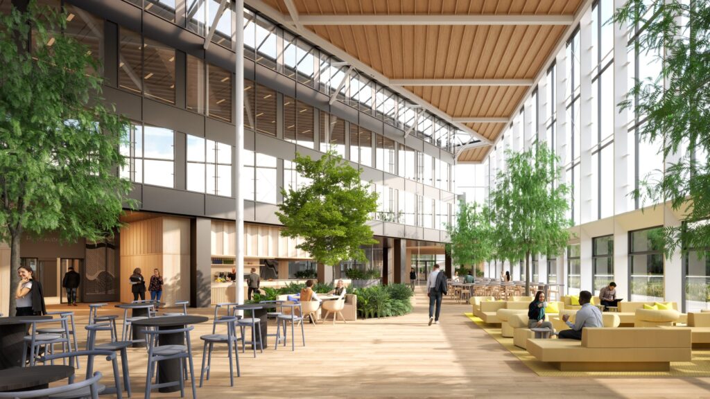 Sunlit biophilic atrium at The Green House Utrecht featuring mature indoor trees, abundant natural daylight, timber finishes, flexible seating areas, and integrated planting designed by MOSS.