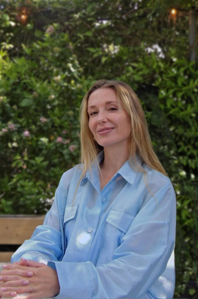 Portrait of Tessa Duste, Co-Founder and Creative Director of MOSS, in a biophilic garden setting surrounded by lush greenery.