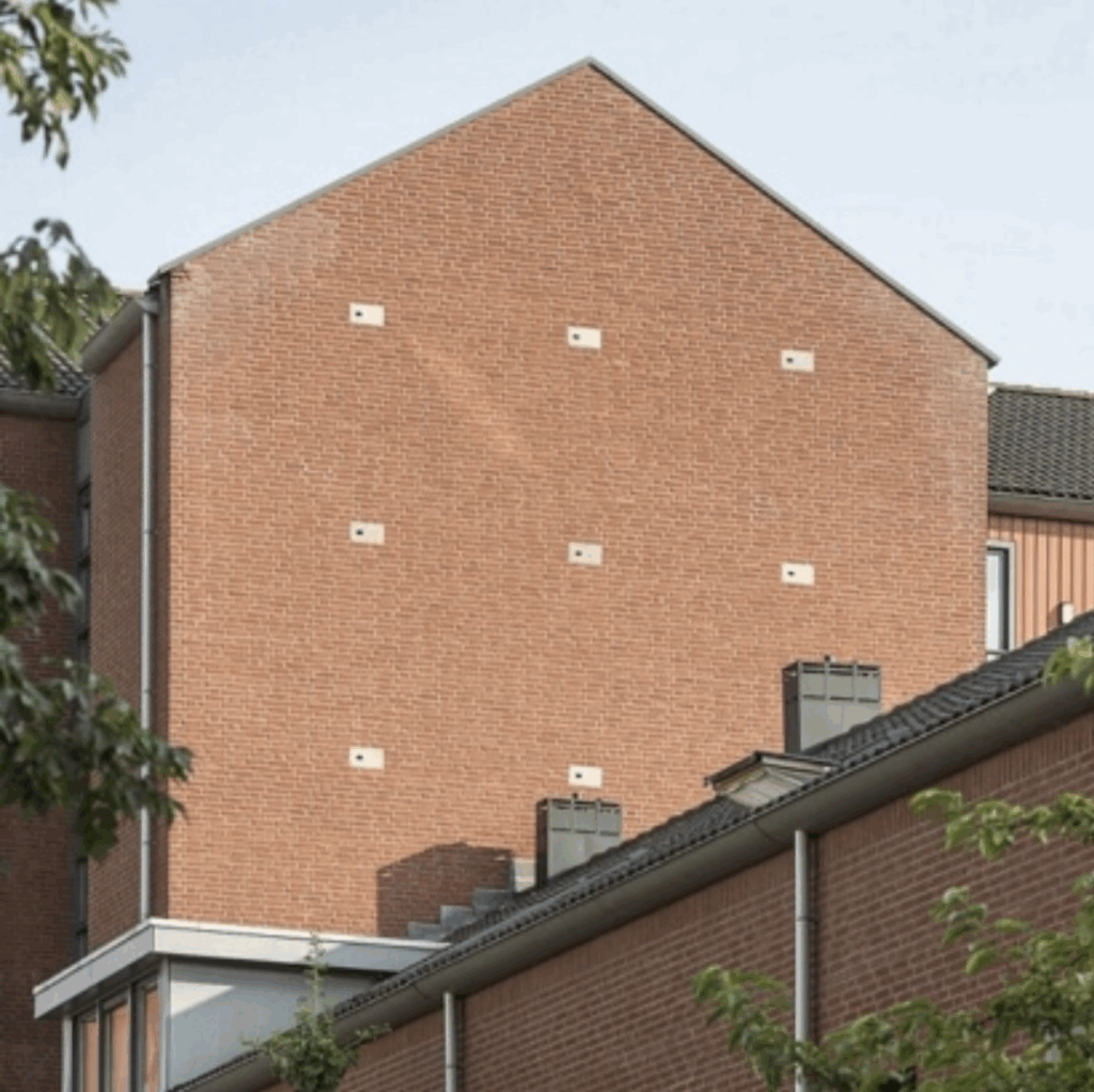 Brick residential building with multiple integrated nesting boxes supporting birds and urban biodiversity