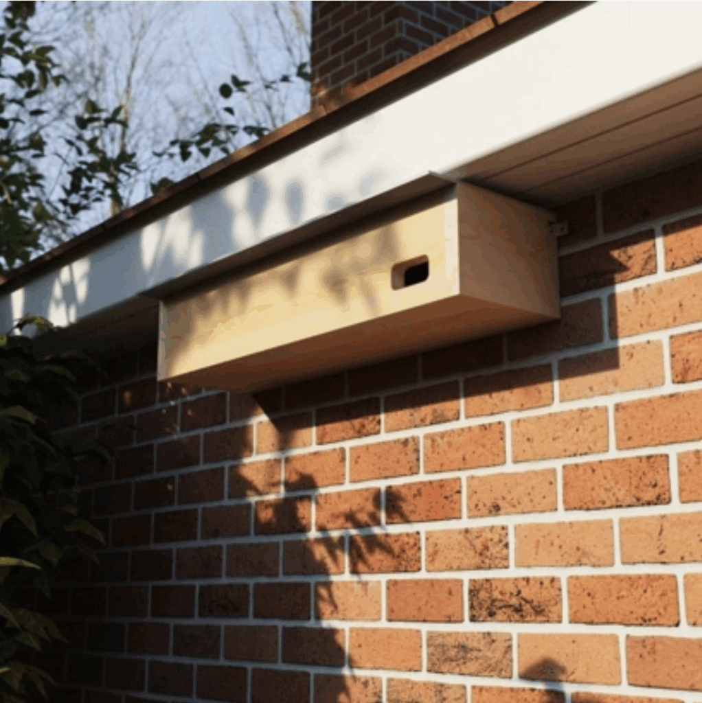 Minimal wooden bird nesting box mounted on brick wall for urban biodiversity and nature-inclusive building design