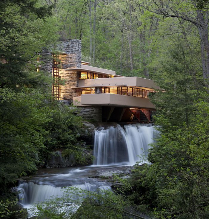 Fallingwater house by Frank Lloyd Wright built over a waterfall surrounded by forest illustrating early biophilic architecture
