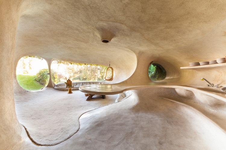 Organic interior architecture with flowing walls, natural materials, and soft forms inspired by cave-like spaces and biophilic design