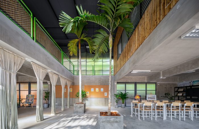 School interior with large indoor trees and plants integrated into open learning environment
