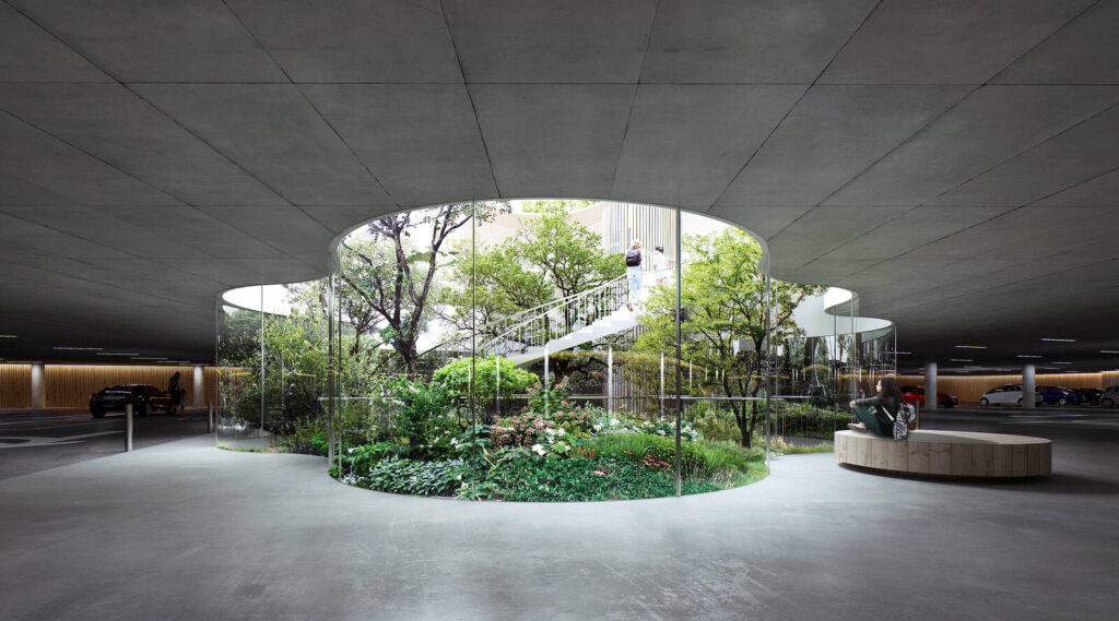 Underground parking structure with central green courtyard, showcasing nature-integrated architecture and biophilic design